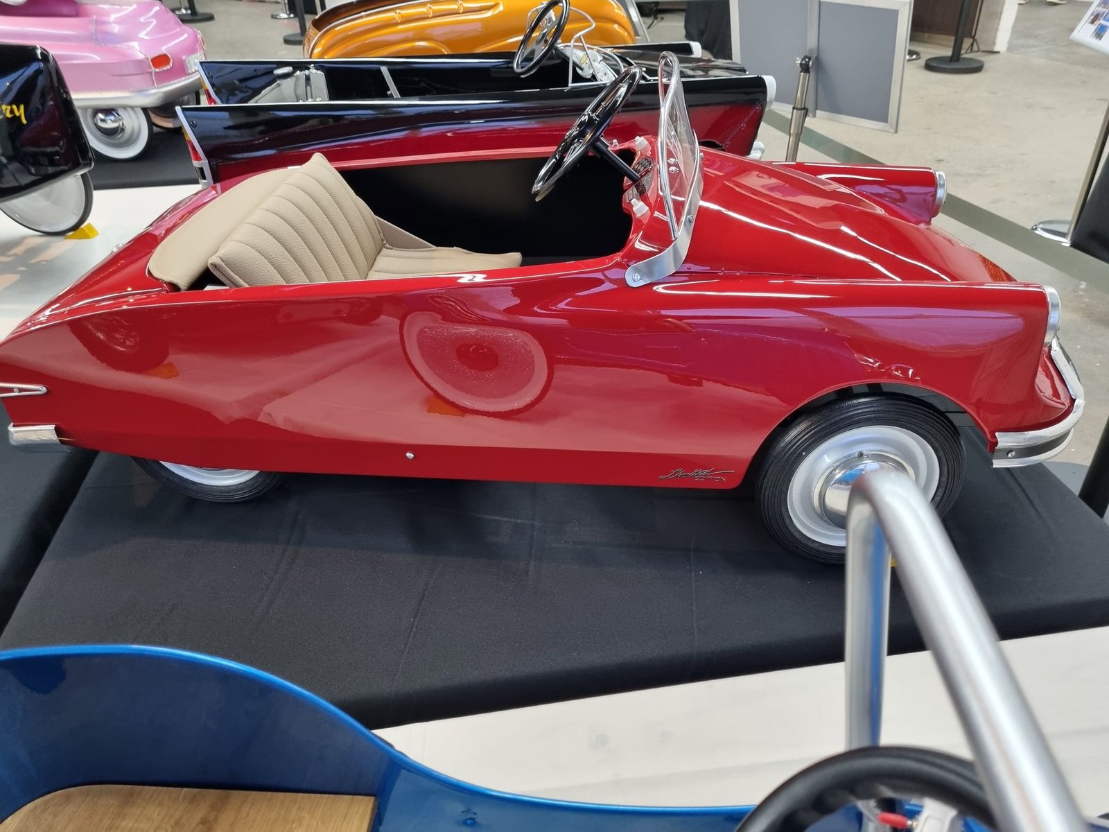 Auf einem Tisch steht ein rotes Spielzeugauto.